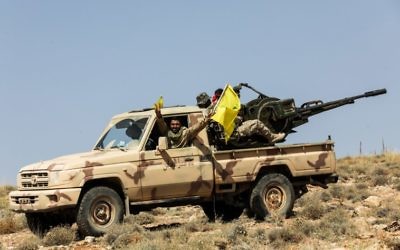 Una fotografía tomada el 26 de julio de 2017 durante un recorrido guiado por el movimiento libanés chiita Hezbolá muestra a los miembros del grupo manejando un arma antiaérea montada en una camioneta en una zona montañosa alrededor de la ciudad libanesa de Arsal a lo largo de la frontera con Siria. (AFP PHOTO / ANWAR AMRO)