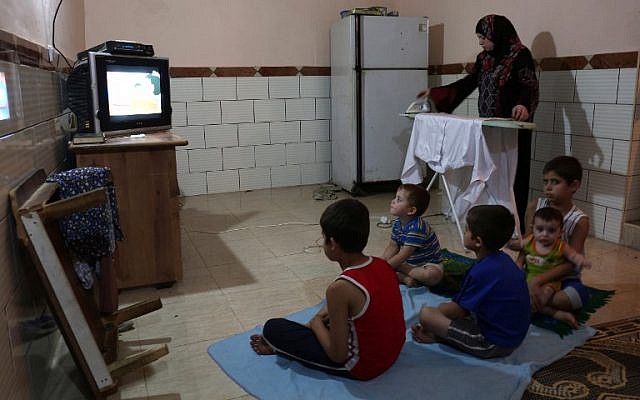 Una mujer palestina planchado de ropa durante las pocas horas de suministro de electricidad que Gaza recibe cada día, en el campo de refugiados de Rafah en el sur de la Franja de Gaza, 31 de julio de 2017. (AFP / SAID KHATIB)