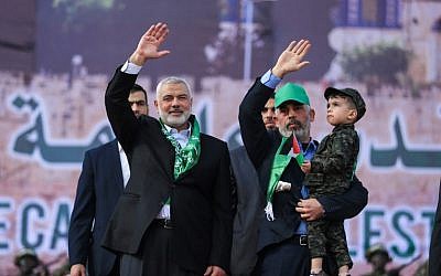 El líder de Hamás Ismail Haniyeh (L) y el líder de Hamás en la Franja de Gaza Yahya Sinwar saludan durante un mitin que marca el 30 aniversario de la fundación del movimiento terrorista islamista en la ciudad de Gaza el 14 de diciembre de 2017. (Mohammed Abed / AFP)