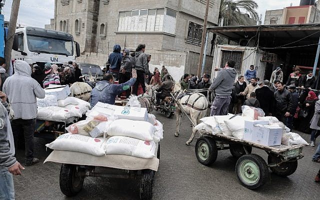 Los palestinos recogen paquetes de ayuda en un centro de distribución de alimentos de las Naciones Unidas en Khan Yunis, al sur de la Franja de Gaza, el 28 de enero de 2018. (Said Khatib / AFP)