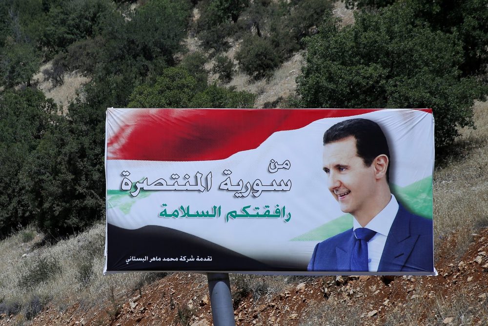 Un cartel del presidente sirio, Bashar Assad, en árabe, que dice "Bienvenido en la victoriosa Siria", se exhibe en la frontera entre Líbano y Siria, el 20 de julio de 2018. (Hassan Ammar / AP)