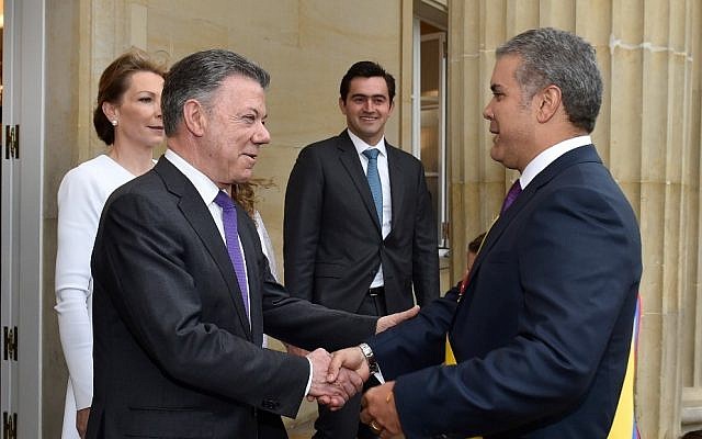 Esta foto, publicada por la oficina de prensa presidencial de Colombia, muestra al presidente saliente Juan Manuel Santos de Colombia, en el centro, dando la bienvenida al recién nombrado presidente Ivan Duque en el palacio presidencial después de su ceremonia de inauguración en Bogotá, Colombia, el martes 7 de agosto de 2018. (Presidencial de Colombia oficina de prensa a través de AP)