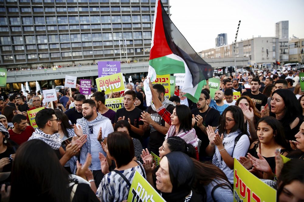 Los árabes israelíes sostienen una bandera palestina durante una protesta contra el proyecto de ley de la nación judía en Tel Aviv, Israel, el sábado 11 de agosto de 2018. (AP / Ariel Schalit)