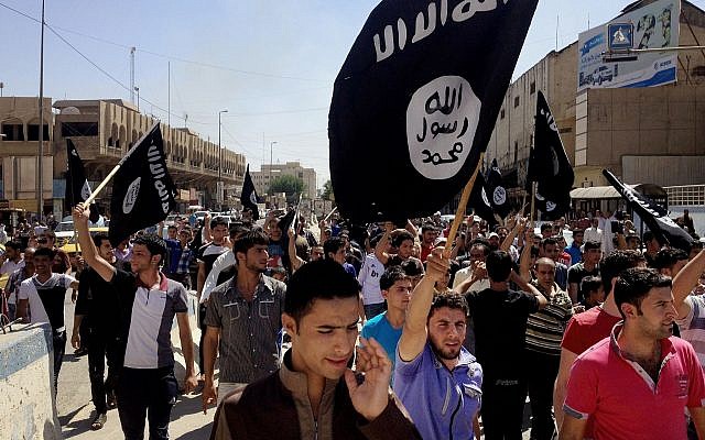 ARCHIVO - En esta foto de archivo del 16 de junio de 2014, los manifestantes corean consignas de grupos de estado pro-islámicos mientras portan las banderas del grupo frente a la sede del gobierno provincial en Mosul, Irak (AP Photo, File)