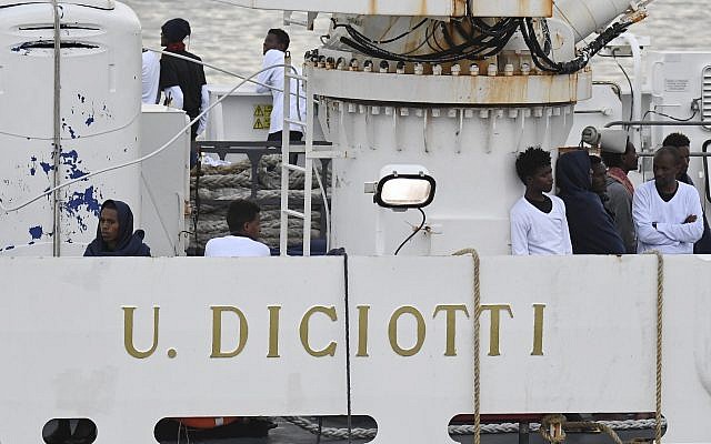 Los inmigrantes se paran en la cubierta del barco de la Guardia Costera italiana Diciotti, amarrado en el puerto de Catania, el 21 de agosto de 2018 (AP Photo / Salvatore Cavalli)