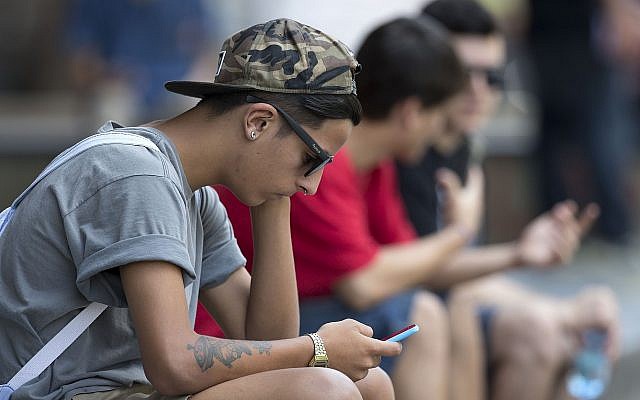 Ilustrativo: un joven revisa su teléfono celular (AP Photo / Andre Penner)