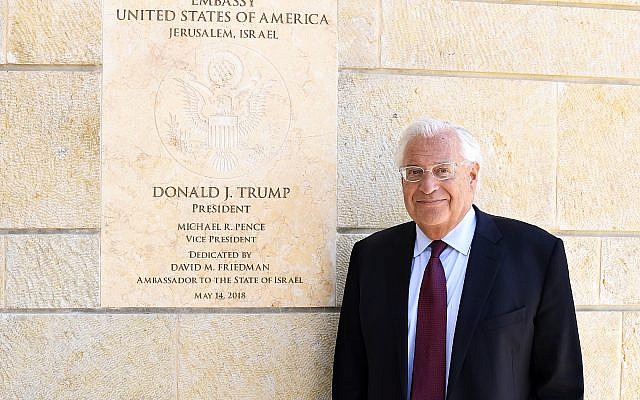 Embajador de los Estados Unidos en Israel David Friedman en la embajada de los Estados Unidos, Jerusalén, 30 de mayo de 2018, posando delante de una entrevista del Times of Israel (Matty Stern, embajada de los Estados Unidos en Jerusalén)