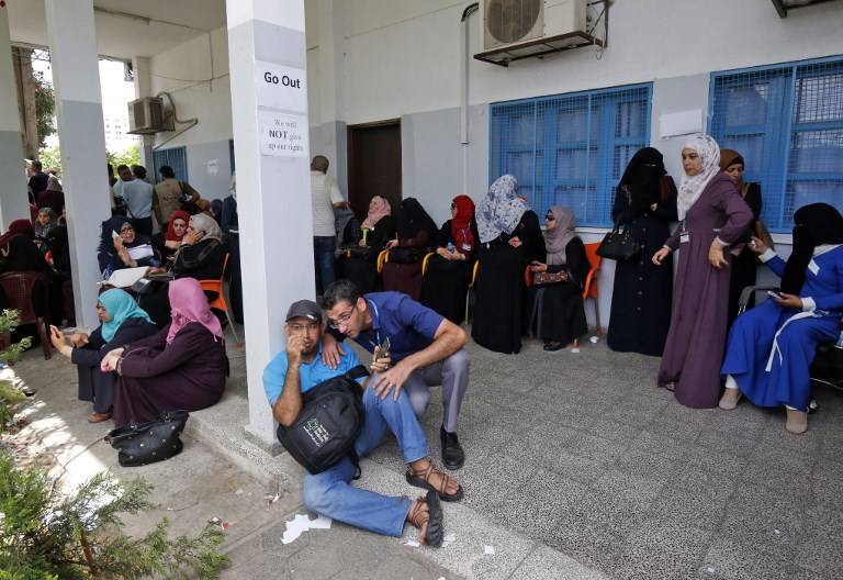 Empleados palestinos de la agencia de las Naciones Unidas para refugiados palestinos UNRWA participa en una protesta contra los recortes de empleos anunciada por la agencia, en su sede en la ciudad de Gaza el 25 de julio de 2018. (SAID KHATIB / AFP)