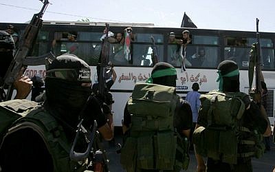 Miembros de Hamás observan autobús que transportaba prisioneros palestinos llega al cruce de Rafah con Egipto en el sur de la Franja de Gaza el 18 de octubre de 2011. (Abed Rahim Khatib / Flash 90)