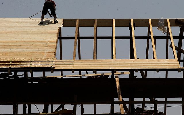 Un trabajador trabaja en una azotea en un sitio de construcción en Jerusalén, 5 de agosto de 2015 (Nati Shohat / Flash90)