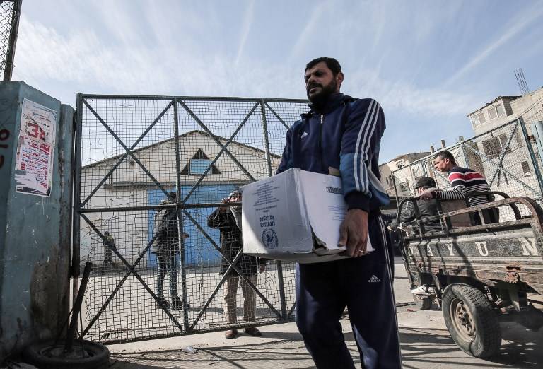 Árabe con estatus de refugiado palestino recoge paquetes de ayuda en un centro de distribución de alimentos de las Naciones Unidas en Rafah, en el sur de la Franja de Gaza, el 21 de enero de 2018. (AFP / Said Khatib)