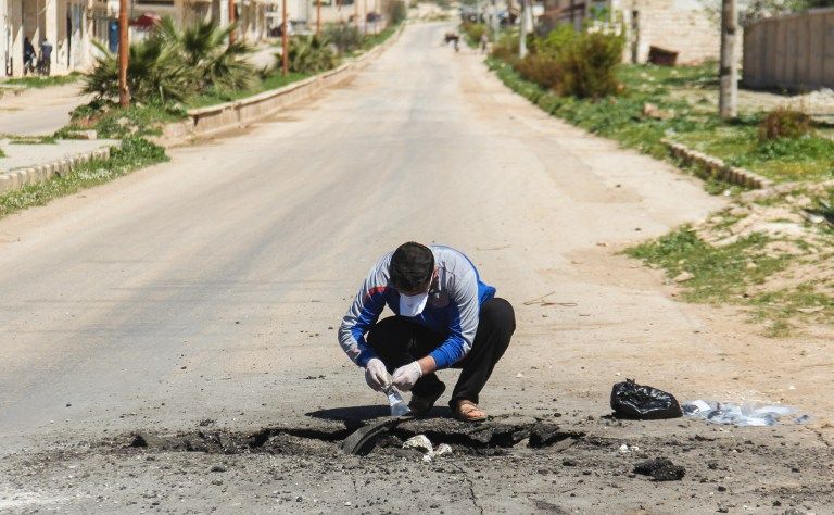 Un hombre sirio recoge muestras del sitio de un supuesto ataque con gas tóxico en Khan Sheikhoun, en la provincia noroccidental de Idlib, en Siria, el 5 de abril de 2017. (AFP / Omar Haj Kadour)