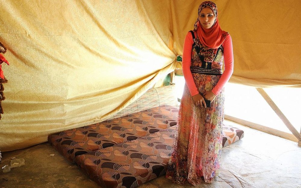 Fadia Ammar Al Mohamad, que no conoció a su marido hasta el día de su boda, se encuentra junto a la cama en la que duermen en su tienda de campaña. (Lisa Khoury / Times of Israel)