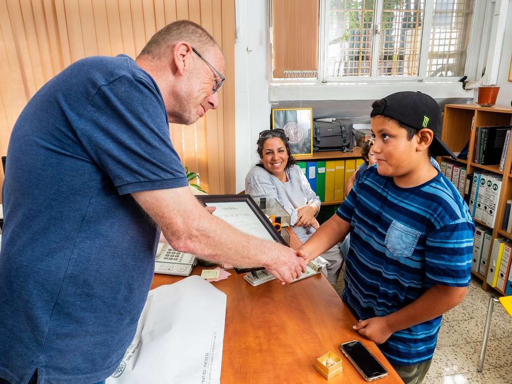 Itamar Barnea, de 10 años, recibió un certificado de “buena ciudadanía” del Dr. Zvi Greenhut de la Autoridad de Antigüedades de Israel, agosto de 2018. (Assaf Peretz / Israel Antiquities Authority)