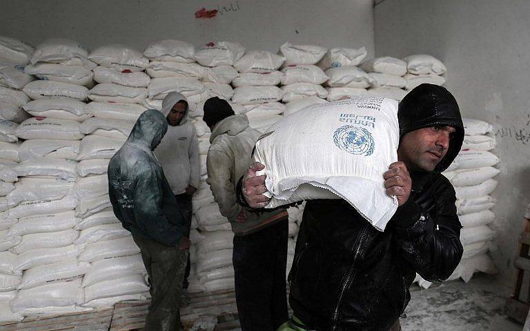 Los palestinos recogen ayuda alimentaria en un centro de distribución de alimentos de las Naciones Unidas en Khan Yunis, al sur de la Franja de Gaza, el 28 de enero de 2018. (Said Khatib / AFP)