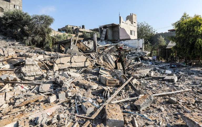 Un miembro de la policía militar de Hamás camina entre los escombros en un sitio que fue atacado por ataques aéreos israelíes en la ciudad de Gaza el 9 de agosto de 2018 (AFP PHOTO / MAHMUD HAMS)