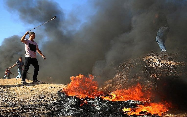 Islamista palestino utiliza un tirachinas durante los enfrentamientos a lo largo de la frontera entre Israel y la Franja de Gaza, en la ciudad de Khan Younis, al sur de Gaza, el 10 de agosto de 2018. (AFP Photo / Said Khatib)