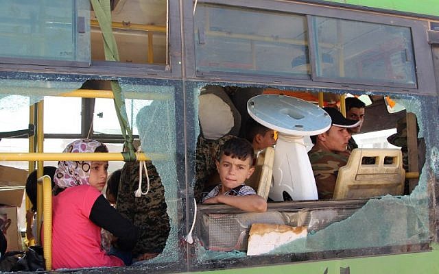 Imagen ilustrativa de los sirios evacuados del área de Fuaa y Kafraya en la provincia de Idlib, mirando por la ventana de un autobús roto durante la evacuación de varios miles de residentes de las dos ciudades pro régimen en el norte de Siria el 19 de julio de 2018. (AFP / STR)