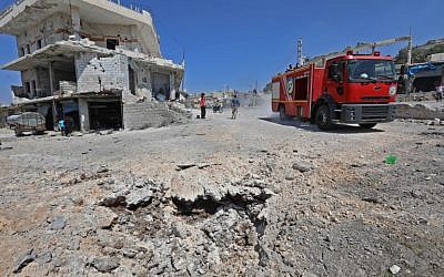 Una foto tomada el 4 de septiembre de 2018 muestra un recorrido de un camión de bomberos por una carretera dañada después de un ataque aéreo ruso en la ciudad de Muhambal, a unos 30 kilómetros al suroeste de la ciudad de Idlib. (AFP / Omar Haj Kadour)