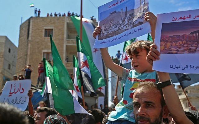 Los manifestantes sirios agitan su bandera nacional mientras se manifiestan contra el régimen y su aliado Rusia, en la ciudad de Idlib, controlada por los rebeldes, el 7 de septiembre de 2018. (AFP / Zein Al Rifai)