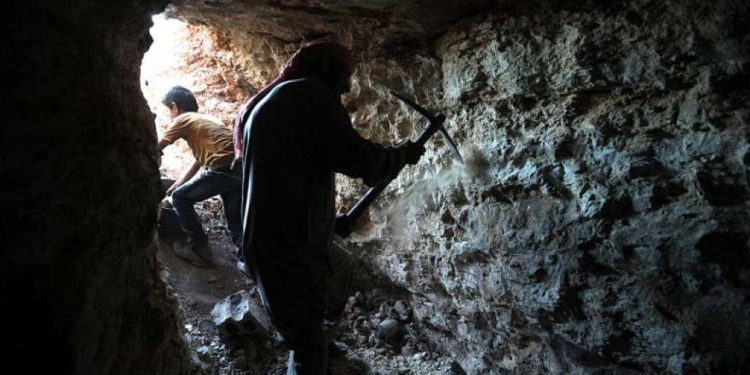 Un hombre usa un pico para cavar una cueva en la aldea siria de Kafr Ain, en el campo meridional de la provincia rebelde de Idlib, el 15 de septiembre de 2018. (AFP / OMAR HAJ KADOUR)