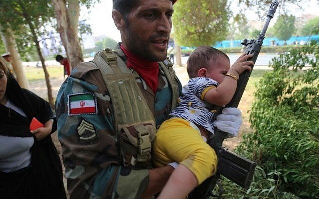 Una imagen puesta a disposición por la agencia iraní Mehr News el 22 de septiembre de 2018 muestra a un soldado iraní que portaba un niño en el sitio de un ataque a un desfile militar en la ciudad iraní de Ahvaz, que conmemoraba el aniversario del estallido de su devastadora guerra de 1980-1988 con el Iraq de Saddam Hussein. (AFP / MEHR NOTICIAS Y AFP PHOTO / Mehdi Pedramkhou)