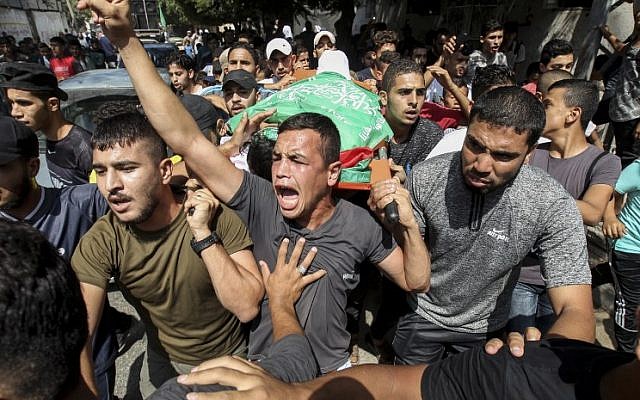 Los deudos llevan el cuerpo de Mohammed al-Houm, de 14 años, muerto durante un ataque violento contra la frontera de Israel, durante su funeral en el campo de refugiados de Bureij, en el centro de Gaza, el 29 de septiembre de 2018. (AFP PHOTO / Anas BABA )