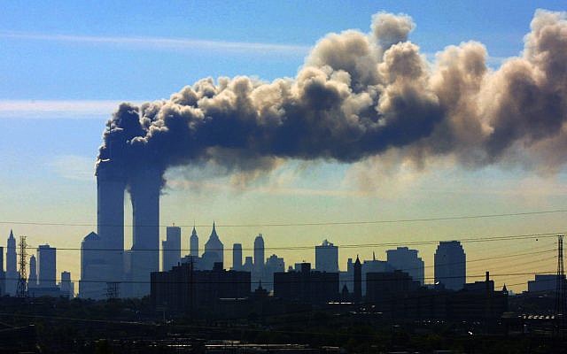 ARCHIVO - En esta foto de archivo del 11 de septiembre de 2001, vista desde la autopista New Jersey Turnpike, cerca de Kearny, Nueva Jersey, se filtraron nubes de humo desde las torres gemelas del World Trade Center en Nueva York después de que los aviones se estrellaran en ambas torres. (Foto AP / Gene Boyars, Archivo)