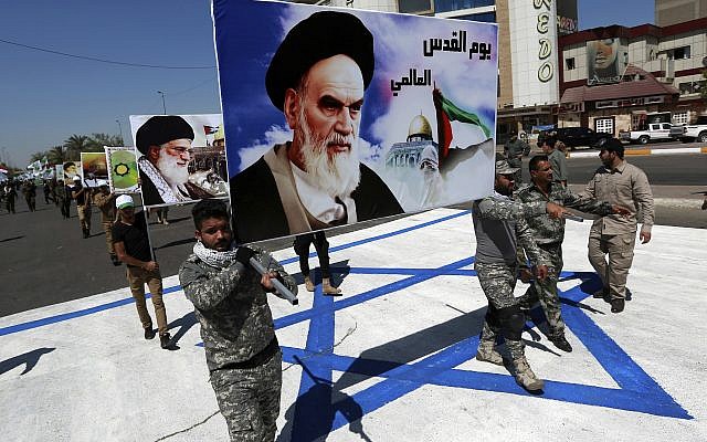 En esta foto de archivo del 23 de junio de 2017, los partidarios de las brigadas iraquíes de Hezbolá, respaldadas por Irán, marchan sobre una representación de una bandera israelí con un retrato del fallecido líder iraní Ayatolá Jomeini y el líder supremo de Irán, el ayatolá Ali Jamenei, en Bagdad, Irak. (AP / Hadi Mizban)