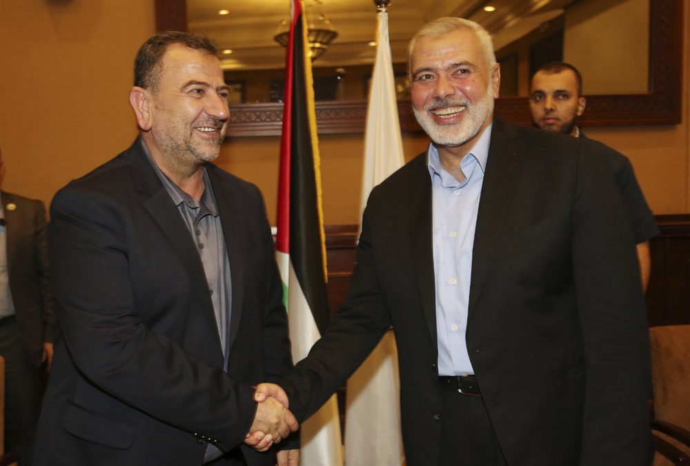 En esta foto publicada por la Oficina de Medios de Hamás, Ismail Haniyeh, a la derecha, el jefe de la oficina política de Hamás, estrecha la mano de su adjunto Saleh el-Arouri a su llegada a Gaza desde El Cairo, Egipto, en la ciudad de Gaza, el jueves, agosto. 2, 2018. (Mohammad Austaz / Hamás Media Office vía AP)