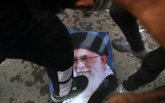 Los manifestantes pisotean un retrato del líder supremo de Irán, el ayatolá Ali Khamenei, durante el asalto y la quema del consulado iraní en la ciudad de Basora, al sur de Irak, el 7 de septiembre de 2018. (AP / Nabil al-Jurani)