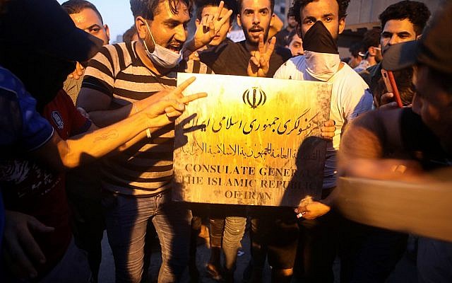 Los manifestantes sostienen un letrero perteneciente al edificio del consulado iraní antes de asaltar y quemar el consulado iraní en la ciudad de Basora, al sur de Irak, el 7 de septiembre de 2018. (AP / Nabil al-Jurani)