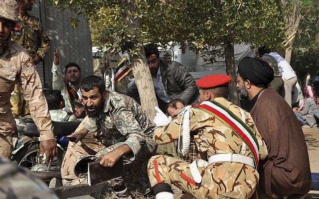 En esta foto proporcionada por la Agencia de Noticias de Estudiantes Iraníes, ISNA, miembros de las fuerzas armadas iraníes y civiles se refugian en un tiroteo durante un desfile militar que conmemora el 38 aniversario de la invasión de Irán en 1980, en la ciudad suroccidental de Ahvaz, Irán, septiembre 22, 2018. (AP Photo / ISNA, Behrad Ghasemi)