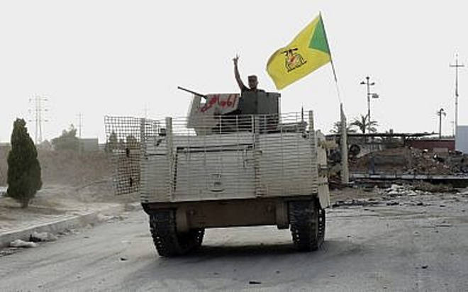 En esta foto del miércoles 27 de mayo de 2015, un combatiente de un vehículo blindado perteneciente a la Brigada chiita de Hezbolá, respaldada por Irán, ondea un v-sign mientras patrulla al este de Ramadi, Iraq. (AP)