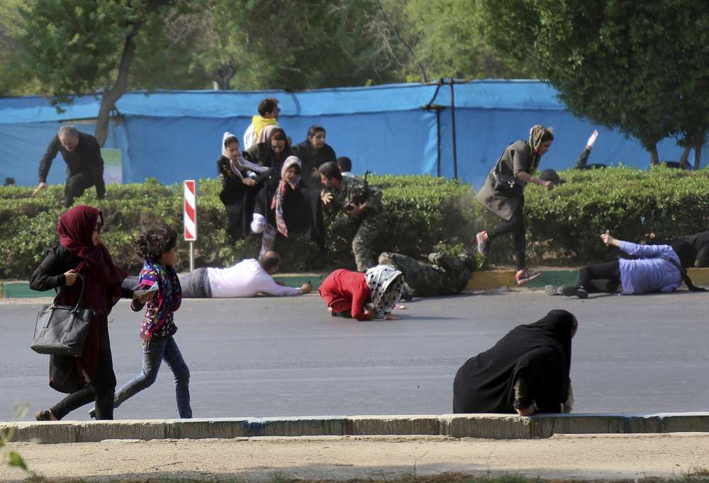 En esta foto provista por la Agencia de Noticias Mehr, los civiles intentan refugiarse, durante un desfile militar que conmemora el 38 aniversario de la invasión de Irán en Irak en 1980, en la ciudad suroccidental de Ahvaz, Irán, 22 de septiembre de 2018 (AP Photo / Mehr Agencia de Noticias, Mehdi Pedramkhoo)