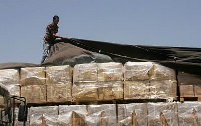 Un palestino revisa un camión cargado con ayuda humanitaria de los EE. UU. Cuando llega a la ciudad palestina de Rafah a través del cruce Kerem Shalom entre Israel y el sur de la Franja de Gaza el 6 de agosto de 2014.