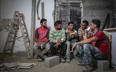 Trabajadores de la construcción palestinos de la aldea de Abadiya en Cisjordania, durante su descanso para tomar café en una casa en proceso de renovación en el asentamiento judío de Alon, al sur de Jerusalén, el 16 de febrero de 2016. (Hadas Parush / Flash90)