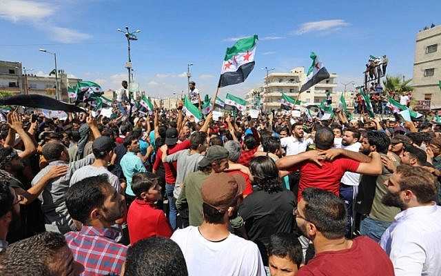 Manifestantes sirios agitan la bandera de la oposición mientras se manifiestan contra el régimen y su aliado Rusia, en la ciudad de Idlib, controlada por los rebeldes, el 7 de septiembre de 2018 (AFP / Omar Haj Kadour)