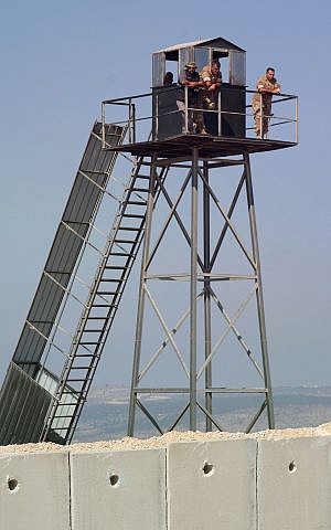 Miembros de las Fuerzas Armadas Libanesas vigilan la construcción de un muro fronterizo israelí desde una torre de vigilancia, cerca de la ciudad israelí de Rosh Hanikra, el 5 de septiembre de 2018. (Judah Ari Gross / Times of Israel)