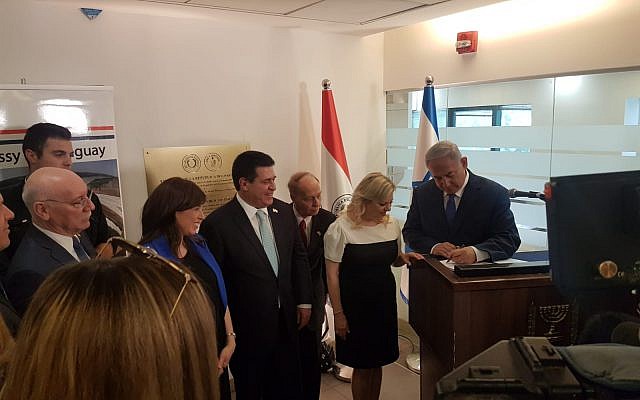 El primer ministro Benjamin Netanyahu, a la derecha, firma el libro de visitas en la nueva embajada de Paraguay en Jerusalén mientras su esposa Sara y el presidente de Paraguay Horacio Carter observan, el 21 de mayo de 2018 (Cortesía)