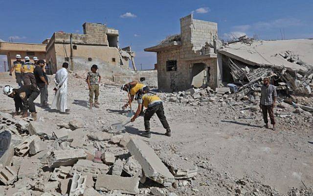 Los equipos de rescate retiran los escombros para abrir una carretera en medio de la destrucción causada por los bombardeos de las fuerzas gubernamentales en la localidad de Al Habit, en los bordes meridionales de la provincia de Idlib, controlada por los rebeldes, el 10 de septiembre de 2018. / (AFP PHOTO / OMAR HAJ KADOUR)