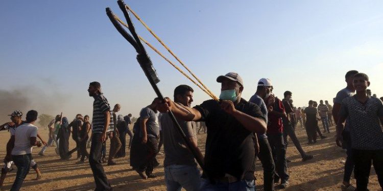 Un islamista palestino arroja piedras a las fuerzas israelíes durante una campaña masiva de infiltración desde Gaza a Israel, al este de Khan Yunis en el sur de la Franja de Gaza el 24 de agosto de 2018. (AFP PHOTO / SAID KHATIB)