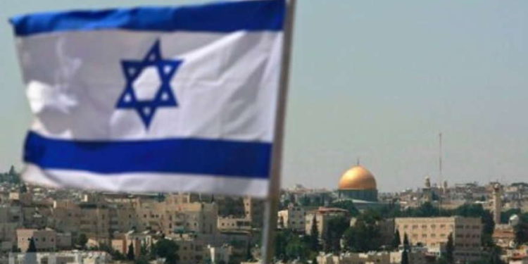 La bandera de Israel volando en Jerusalén con el Monte del Templo en la distancia