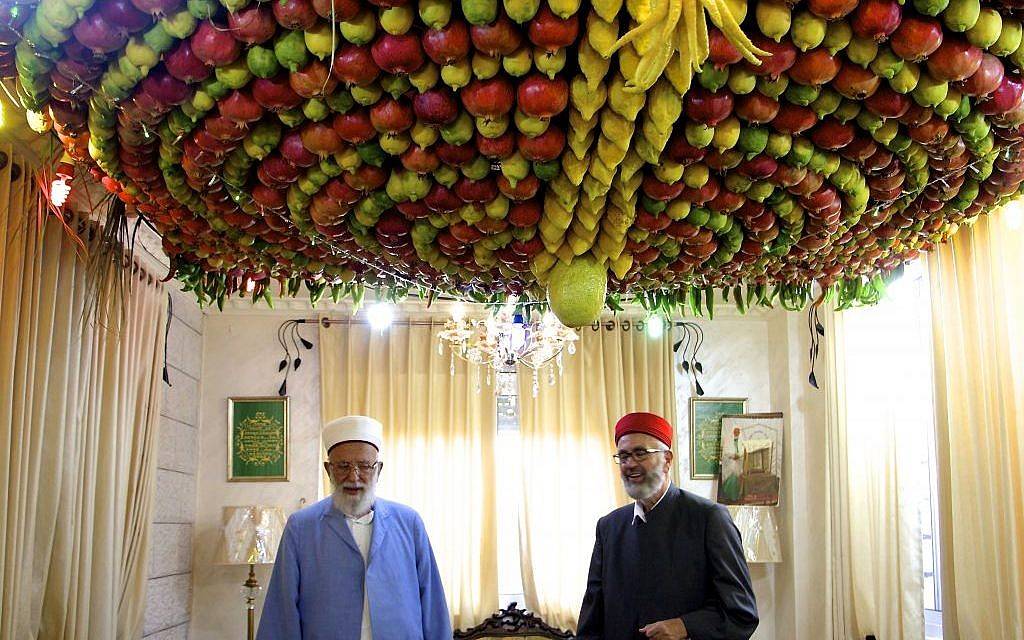 Ilustrativo: el sumo sacerdote samaritano, Abdullah Wassef Tawfiq, se encuentra con su hermano Husney Cohen dentro de su sala de estar con una 'sucá' casera hecha de fruta fresca para las festividades de Tabernaculos, o Sucot, en el monte Gerizim cerca de la ciudad de Nablus, el 18 de octubre de 2016. (Dov Lieber / Times of Israel)