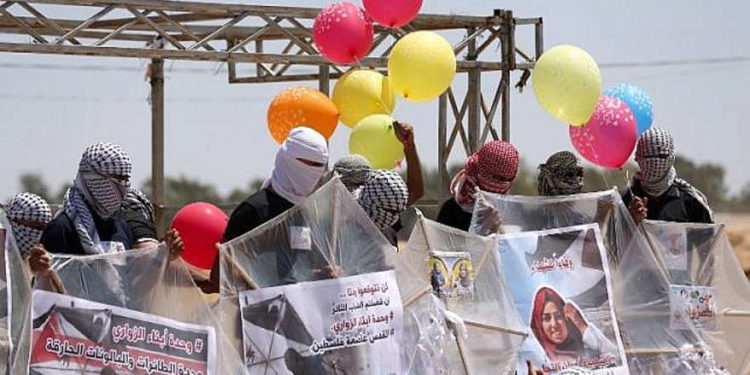 Los palestinos cargan cometas y globos con material inflamable para volar hacia Israel, en la frontera Israel-Gaza en al-Bureij, en el centro de la Franja de Gaza, el 14 de junio de 2018. (AFP Photo / Mahmud Hams