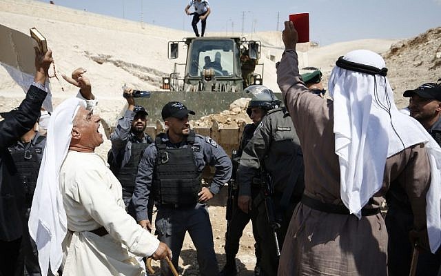 Los manifestantes palestinos corean consignas y se enfrentan a las fuerzas israelíes el 14 de septiembre de 2018, mientras se manifiestan contra el bloqueo de la carretera que conduce a la aldea beduina palestina de Khan al-Ahmar en Judea y Samaria. (AFP PHOTO / ABBAS MOMANI)