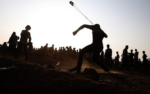 Un palestino lanza una piedra hacia las fuerzas israelíes durante los ataques a lo largo de la valla fronteriza, al este de la ciudad de Gaza el 28 de septiembre de 2018. (Foto de AFP / Said Khatib)