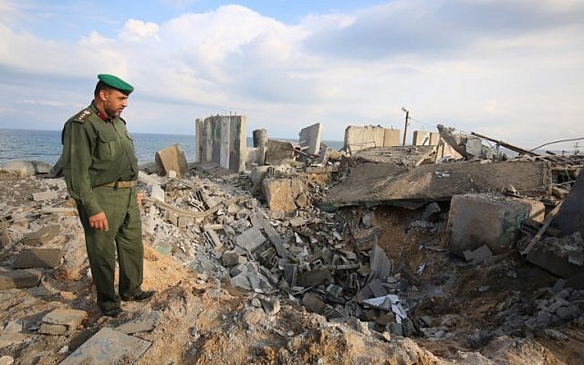 Un oficial de Hamás camina sobre escombros después de un ataque aéreo israelí en represalia cerca de la ciudad de Rafah, en el sur de la Franja de Gaza, después de que un cohete impactara en una casa en la ciudad israelí de Beerseba el 17 de octubre de 2018. (Said Khatib / AFP)