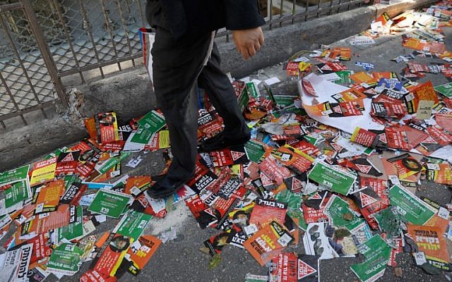 Un hombre judío camina en una calle llena de carteles de campaña electoral para las próximas elecciones municipales de Jerusalén, en Jerusalén el 28 de octubre de 2018. (MENAHEM KAHANA / AFP)