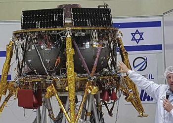 Opher Doron, gerente general de la división espacial de Israel Aerospace Industries, habla junto al módulo lunar SpaceIL, en una "sala limpia" especial donde se está desarrollando la nave espacial, durante una gira de prensa de sus instalaciones cerca de Tel Aviv, Israel, el 10 de julio. , 2018. (Foto AP / Ilan Ben Zion)